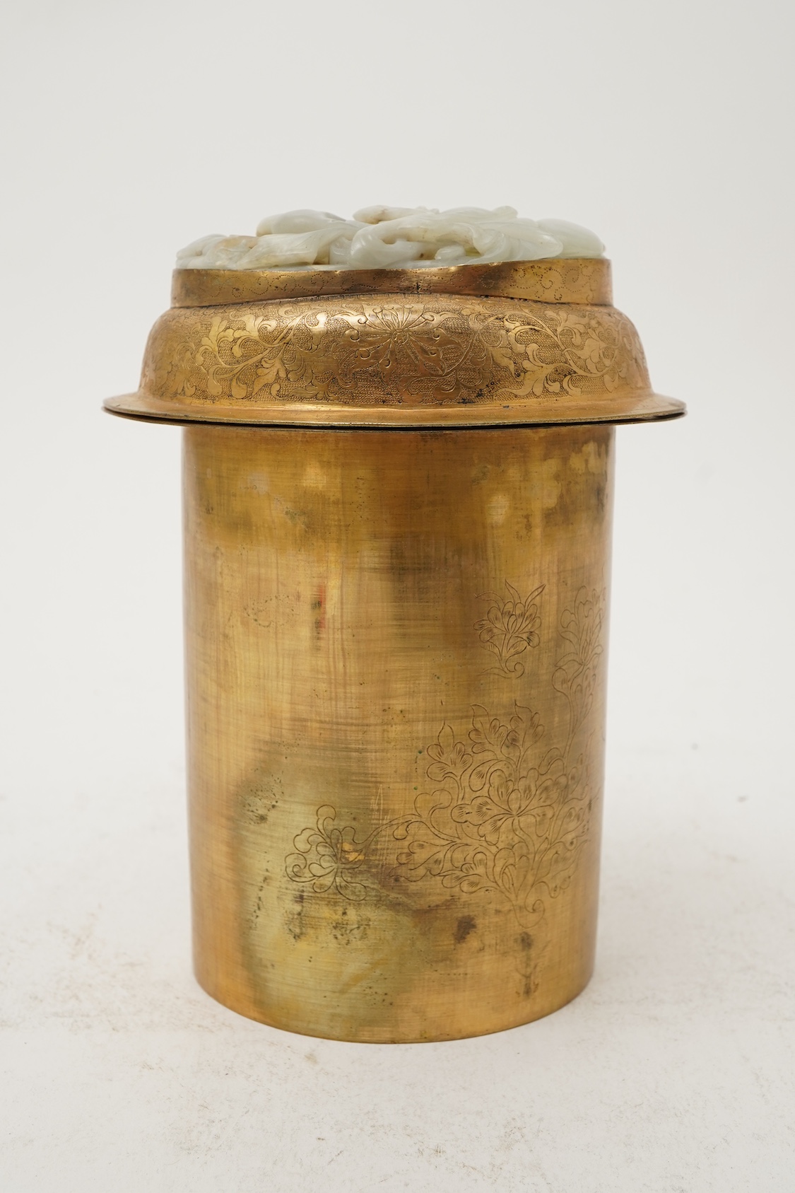A Chinese pale celadon jade oval plaque, 17th/18th century, mounted on a late Qing gilt copper jar